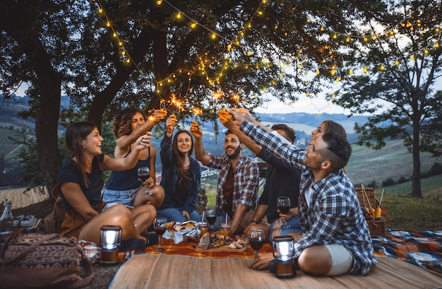 Gruppo di amici che passano il tempo a fare un picnic e un barbecue