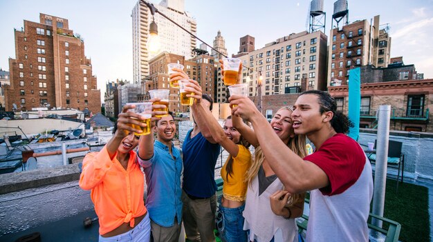 Gruppo di amici che passano insieme tempo su un tetto a New York City, concetto di stile di vita con persone felici