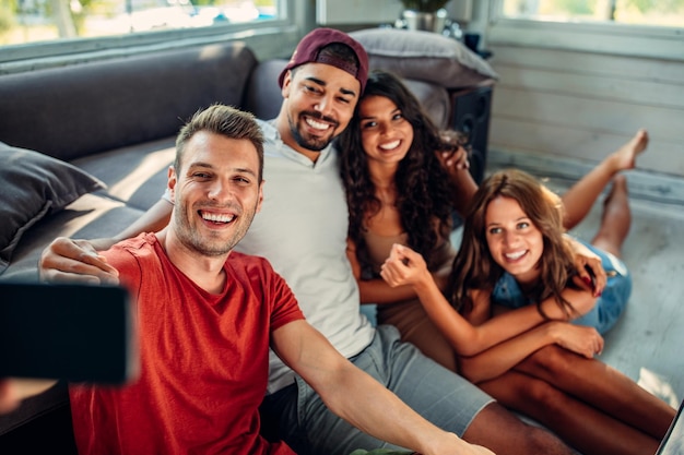 Gruppo di amici che prendono selfie al chiuso