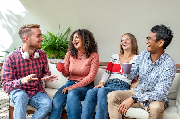 Gruppo di amici che ridono e bevono caffè, incontro di persone della generazione z, studenti adulti in erasmus, persone multiculturali e birazziali che si divertono