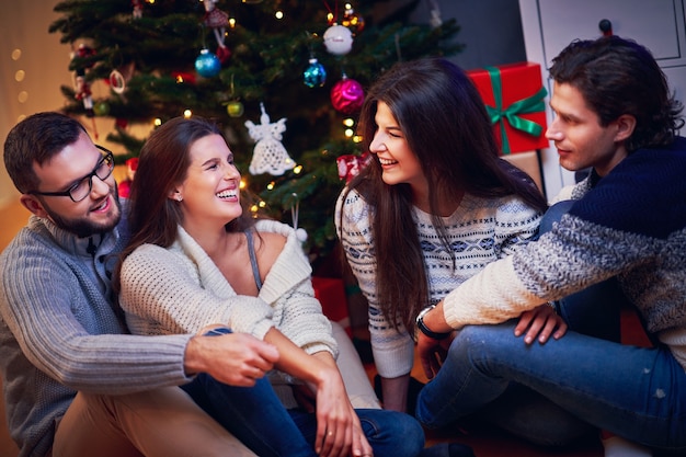 gruppo di amici che si scambiano i regali di Natale a casa