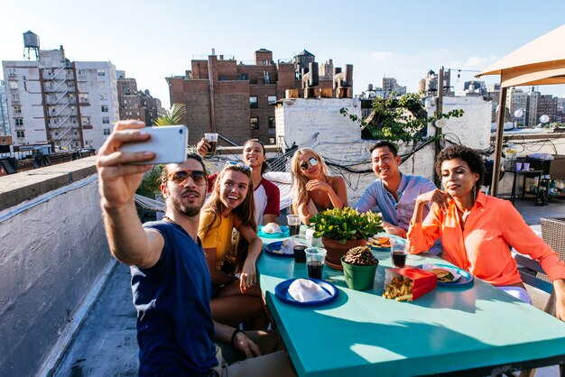 Gruppo di amici che spendono insieme tempo su un tetto a New York City, concetto di stile di vita con la gente felice