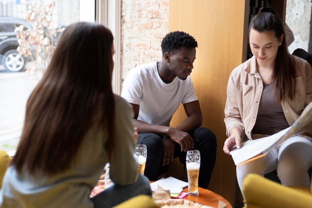 Gruppo di amici che stanno programmando un viaggio in un caffè