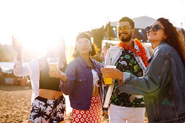 Gruppo di amici con birra che ballano e si divertono insieme al festival musicale Concetto di celebrazione