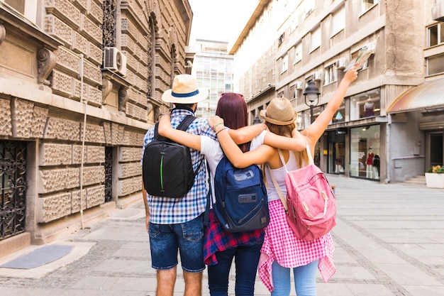 Gruppo di amici con lo zaino in piedi sulla strada