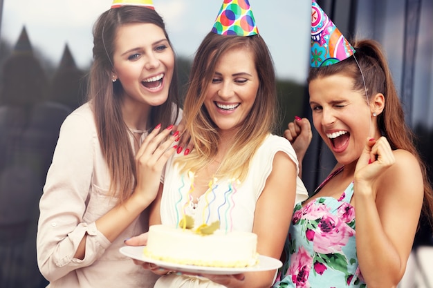 Gruppo di amici con torta che festeggia il compleanno