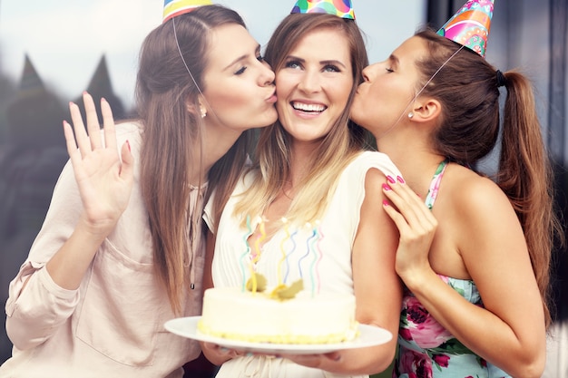 Gruppo di amici con torta e regali che festeggiano il compleanno