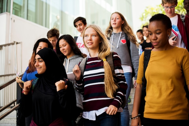 Gruppo di amici della scuola che cammina giù per la scala