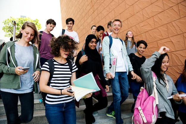 Gruppo di amici della scuola che cammina giù per la scala