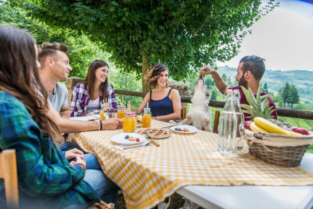 Gruppo di amici facendo colazione in una fattoria