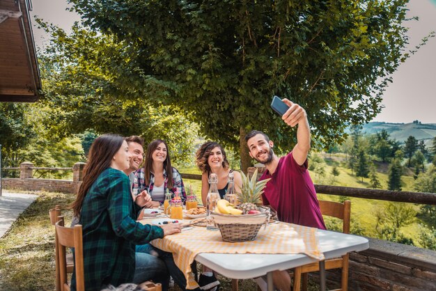 Gruppo di amici facendo colazione in una fattoria