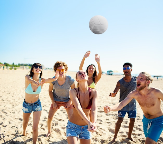 Gruppo di amici felici che giocano a beach volley