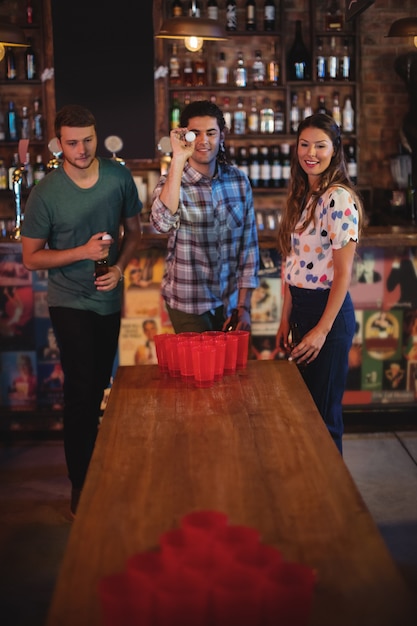 Gruppo di amici felici che giocano a birra pong gioco