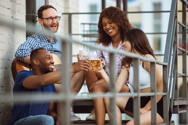 Gruppo di amici felici che hanno festa della birra in giornata estiva.