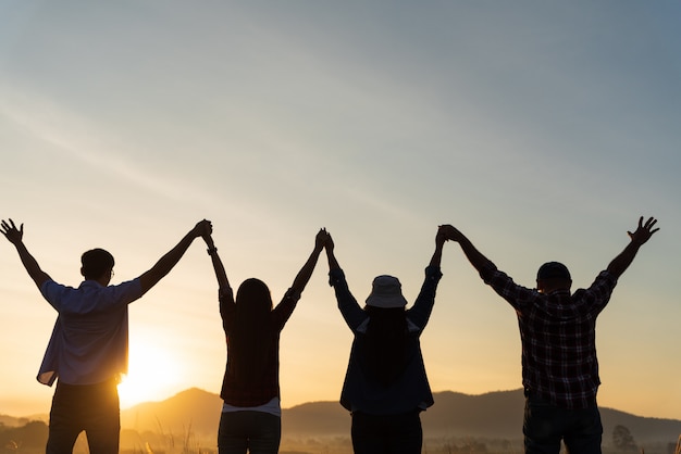 Gruppo di amici felici si divertono insieme con le braccia alzate