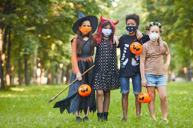 Gruppo di amici in costumi di Halloween mentre in piedi nel parco che celebrano la festa di Halloween