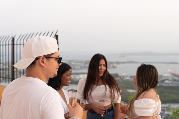 Gruppo di amici latini che si godono un cocktail a una festa all'aperto