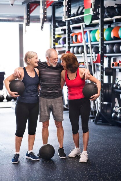 Gruppo di anziani in forma con palle mediche in palestra