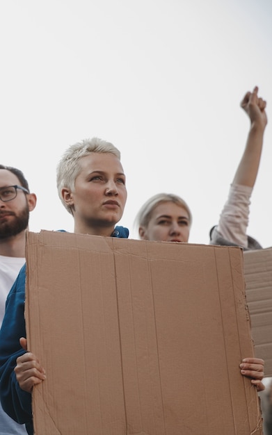 Gruppo di attivisti che danno slogan in un raduno uomini e donne che marciano insieme in una protesta nel