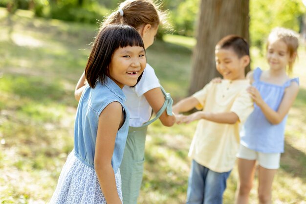 Gruppo di bambini asiatici e caucasici che si divertono nel parco