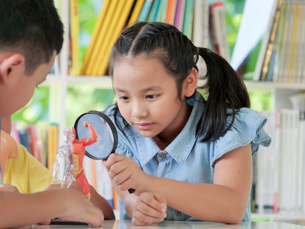 Gruppo di bambini asiatici gioiosi nella lezione di Biologia. Concetto di scuola casa.