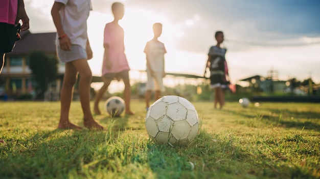 gruppo di bambini che si divertono giocando a calcio di strada per l'esercizio nella zona rurale della comunità