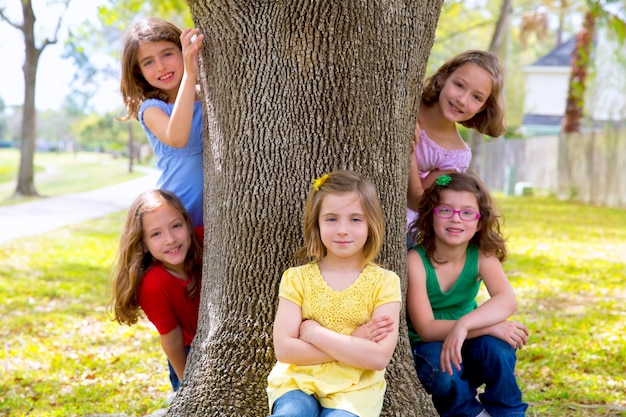 Gruppo di bambini di sorelle ragazze e amici sul tronco d&#39;albero