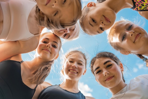 Gruppo di bambini e ragazze con allenatore femminile nel cerchio come amicizia