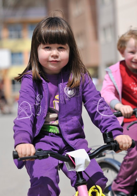 gruppo di bambini felici che imparano a guidare la bicicletta all'aperto nella bella giornata di sole primaverile