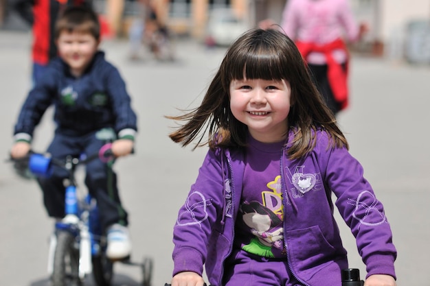 gruppo di bambini felici che imparano a guidare la bicicletta all'aperto nella bella giornata di sole primaverile