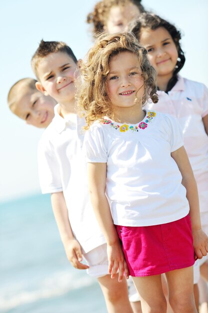 gruppo di bambini felici sulla spiaggia che si divertono e giocano