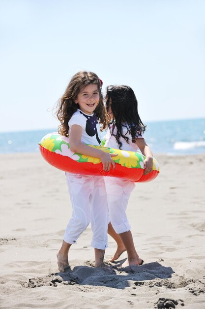 gruppo di bambini felici sulla spiaggia che si divertono e giocano