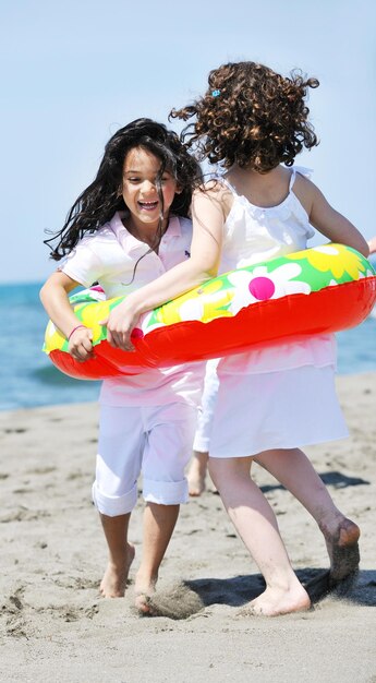 gruppo di bambini felici sulla spiaggia che si divertono e giocano