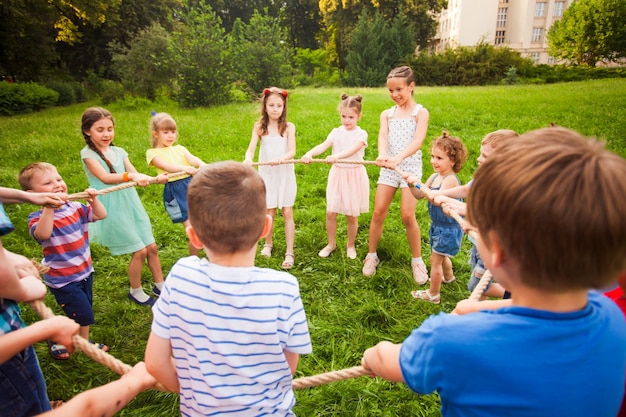 Gruppo di bambini in piedi in cerchio con una corda all'aperto