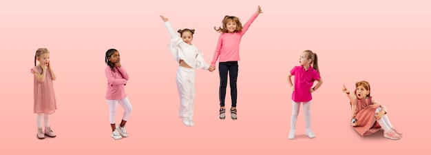 Gruppo di bambini o alunni delle scuole elementari in abiti casual colorati su studio rosa