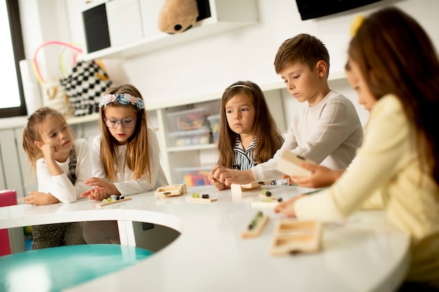 Gruppo di bambini piccoli che giocano con giocattoli educativi in legno in età prescolare