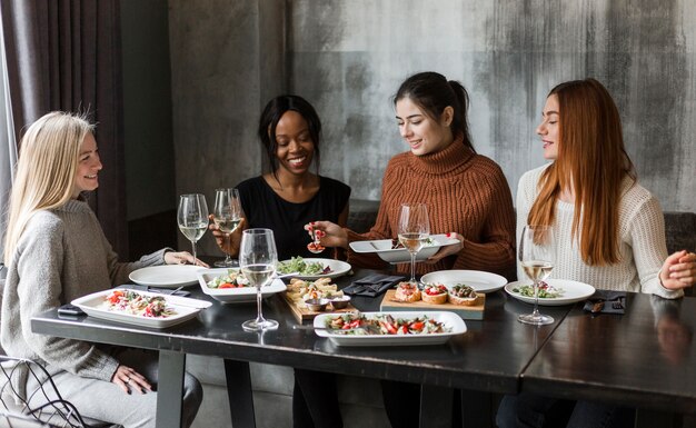 Gruppo di belle donne che godono insieme della cena