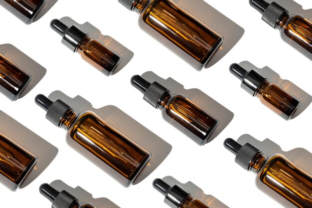 Gruppo di bottiglia di vetro di olio essenziale con pipetta Variazione di bottiglie ambrate Motivo di sfondo