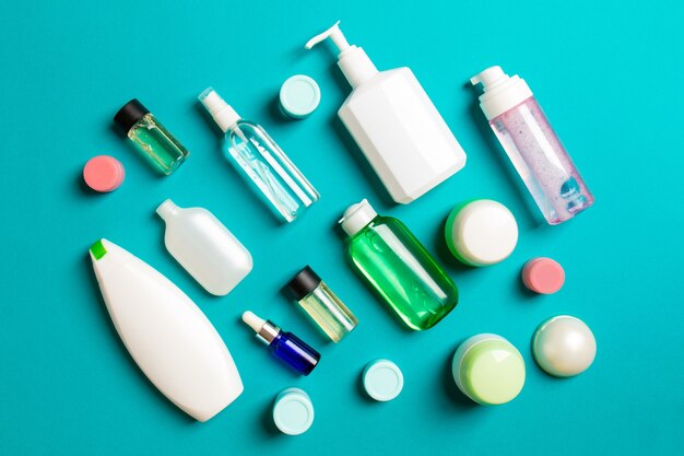 Gruppo di bottiglie di plastica per la cura del corpo Composizione piatta con prodotti cosmetici su sfondo colorato spazio vuoto per la progettazione. Set di contenitori cosmetici bianchi, vista dall'alto con spazio di copia.