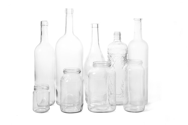 Gruppo di bottiglie di vetro e vasetti su sfondo bianco