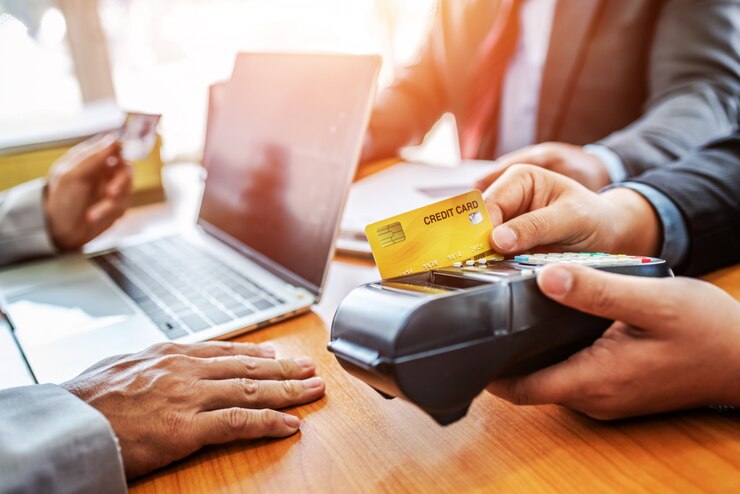 Gruppo di carta di credito della tenuta di affari con il sistema di pagamento di NFC in ufficio moderno.