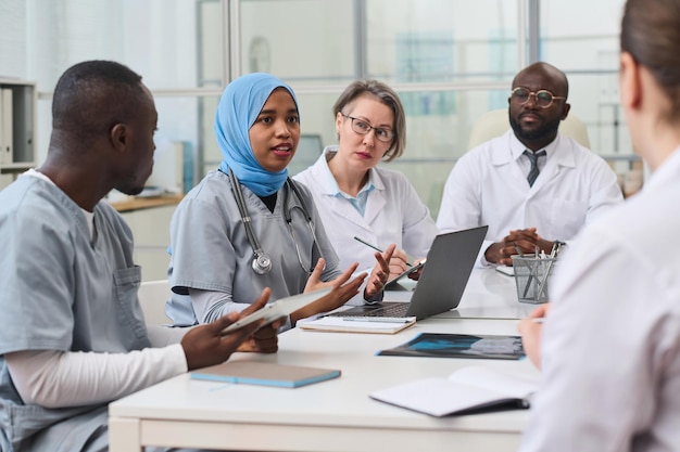 Gruppo di colleghi che discutono insieme di operazioni difficili durante una riunione in ufficio