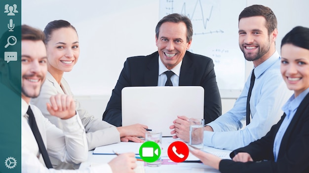 Gruppo di colleghi che sorridono e guardano la telecamera durante la videoconferenza