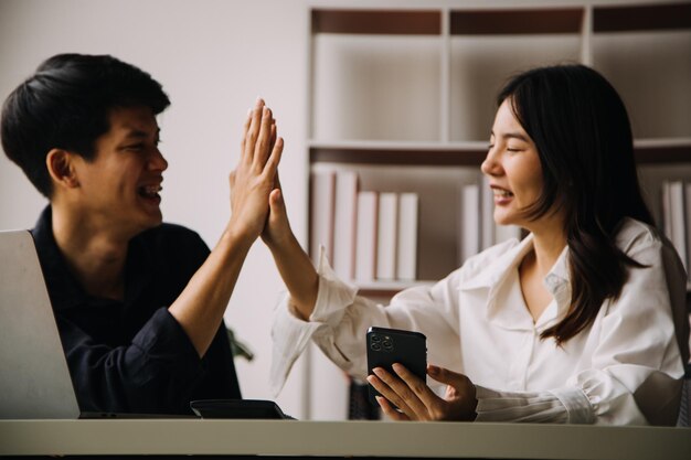 Gruppo di colleghi di lavoro creativi di giovani imprenditori asiatici in ufficio Felici di avere un lavoro di squadra di partnership di successo che celebra il successo e il concetto di successo