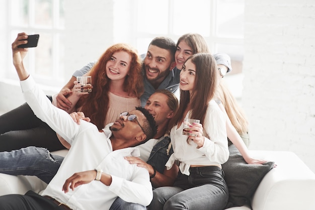 Gruppo di compagni di squadra multirazziali che si divertono durante la pausa e scattano alcune foto