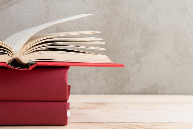 Gruppo di concetto di istruzione e lettura di libri colorati sulla lavagna del muro di cemento del tavolo di legno