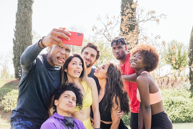 Gruppo di corridori che prendono un selfie in un parco. Fare facce buffe. Inquadratura orizzontale.