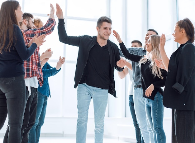 Gruppo di dipendenti felici che si congratulano con il loro collega