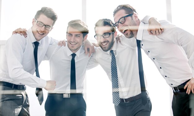Gruppo di dipendenti felici in piedi in un ufficio luminoso il concetto di buon lavoro