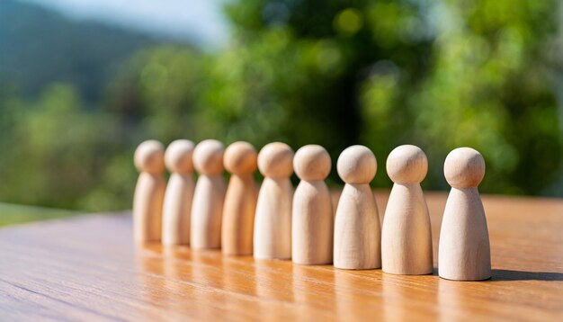 Gruppo di diverse figurine di legno in una linea che simboleggia l'unità, il lavoro di squadra e la comunità nella ga sociale